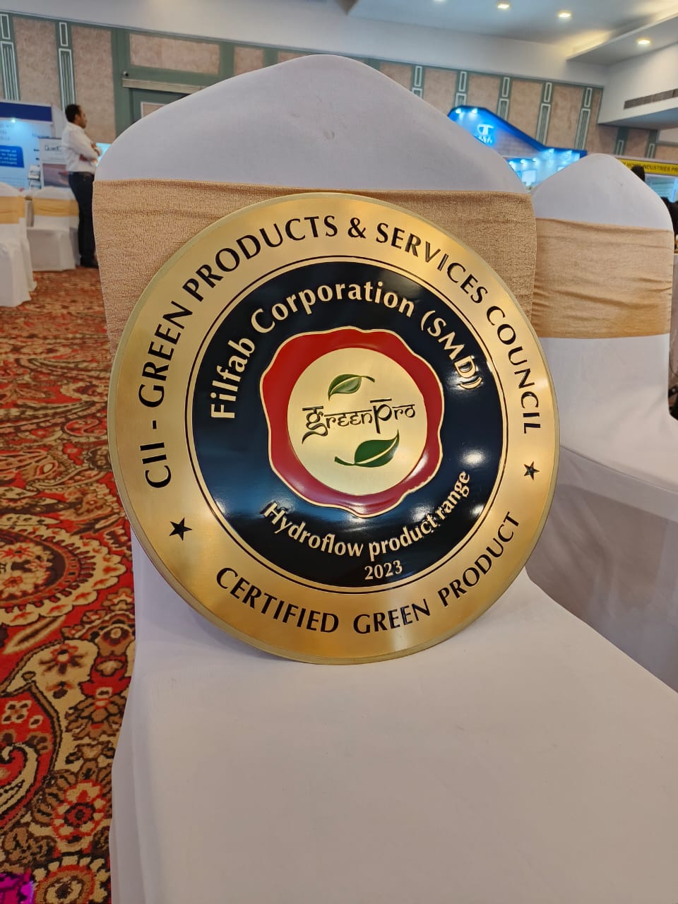 A round golden plaque with the words 'Filfab Corporation (SMD) - Hydroflow product range 2023' on it.