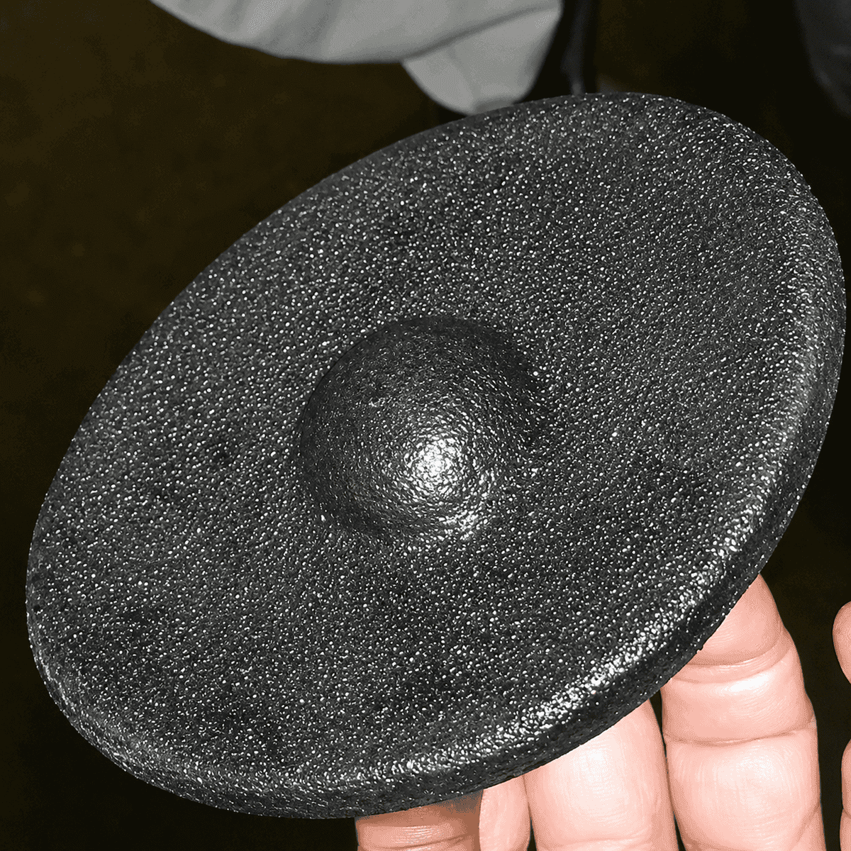 The same water heater disc free of limescale, back to clean bare metal, after HydroFLOW treatment — apple packing facility, US Northwest