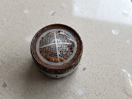 The same jet breaker cleared of biofilm after HydroFLOW treatment, mesh visible — Grand Hotel Terme di Comano, Trentino, Italy