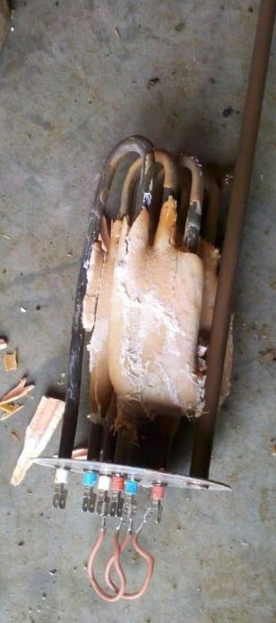 Electric immersion heater from a 3,000-litre hot water cylinder, encased in thick limescale before treatment