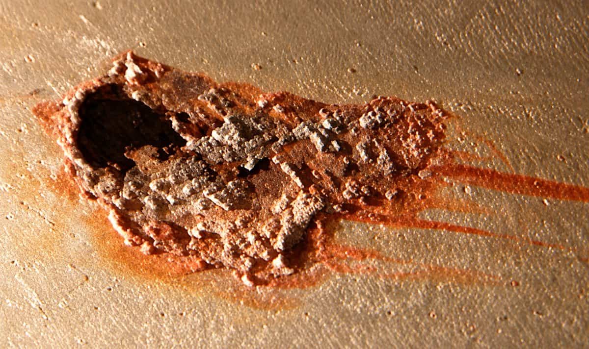 The same MIC nodule after a 15-week HydroFLOW trial: the colony has broken down to a dry crust, exposing the pit it had already made
