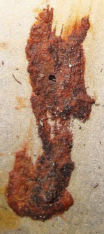 Rust-brown MIC corrosion nodule on a steel starch-line pipe at Boise Paper's Wallula mill, before treatment