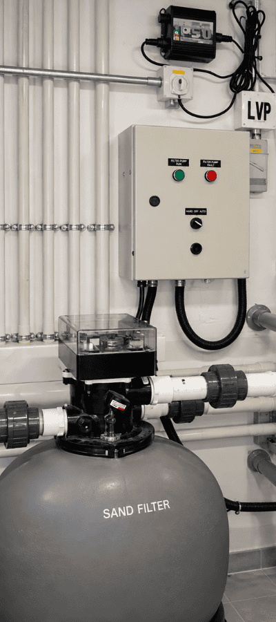 Swimming pool plant room with a sand filter, multiport valve, pump control panel and PVC circulation pipework